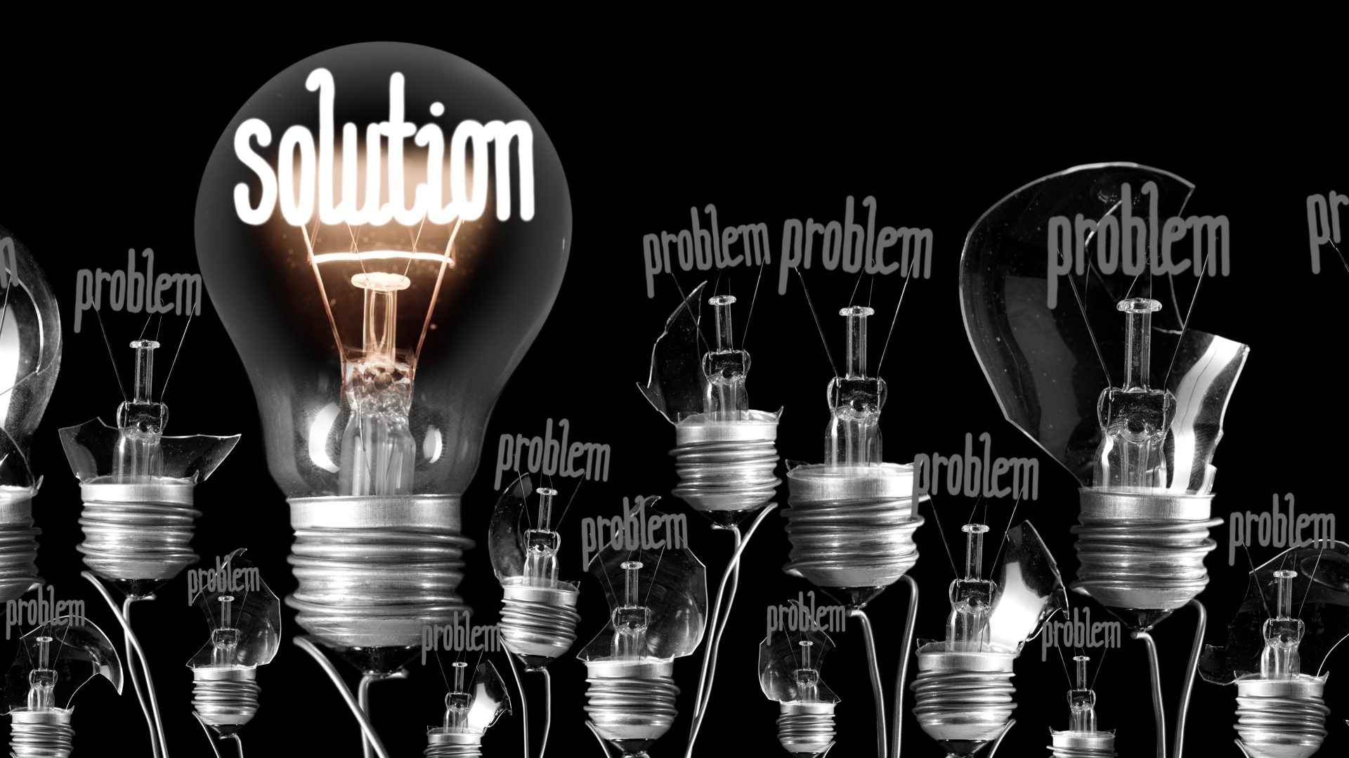 Large group of broken and shining light bulbs with fibers in a shape of Problem and Solution isolated on black background
