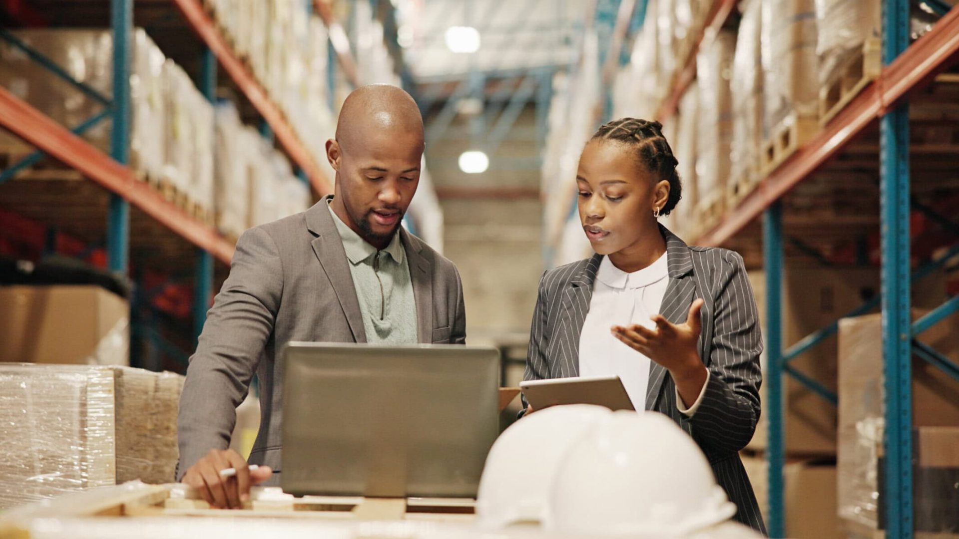 Inventory management professionals analyzing data in a warehouse.
