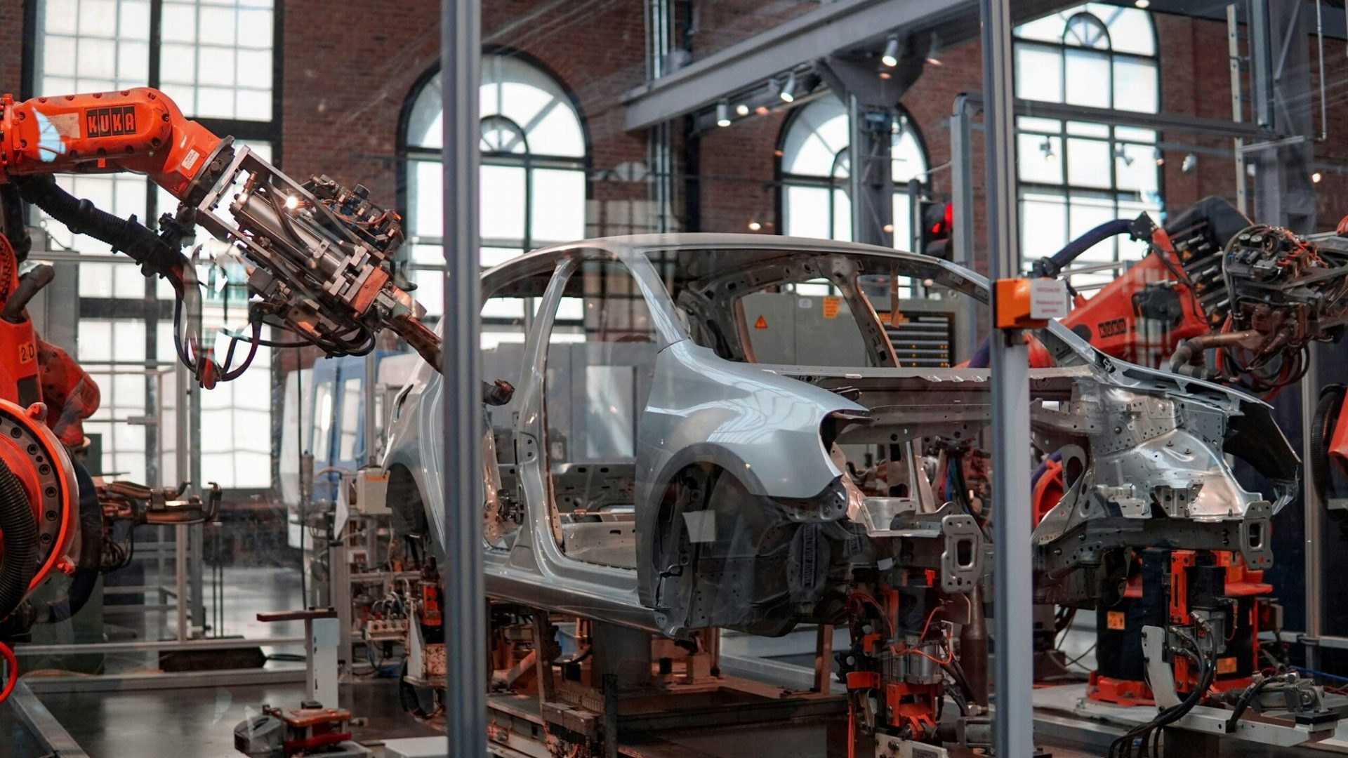 Robotic arms assembling a car in an industrial manufacturing facility.